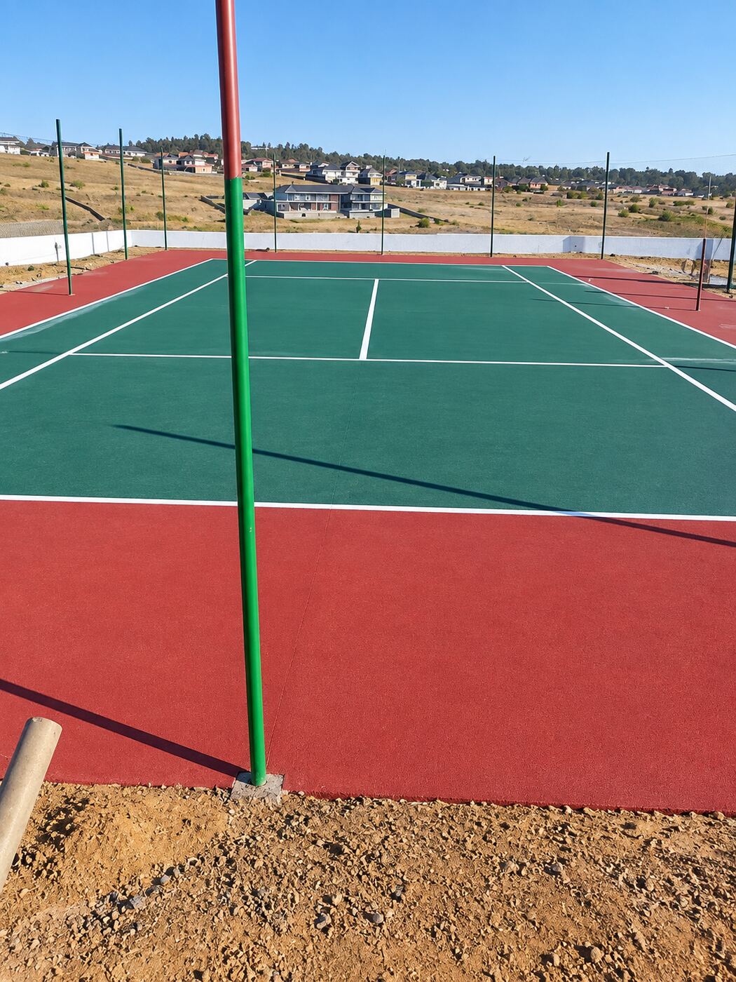 Completed green and red netball courts at a school